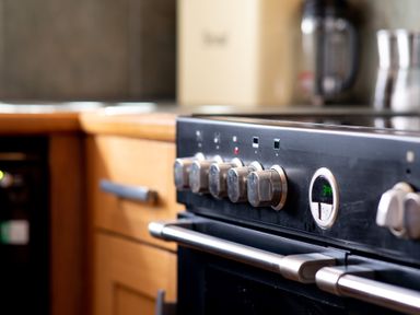 A kitchen with a close up of a stove with knobs and oven handles