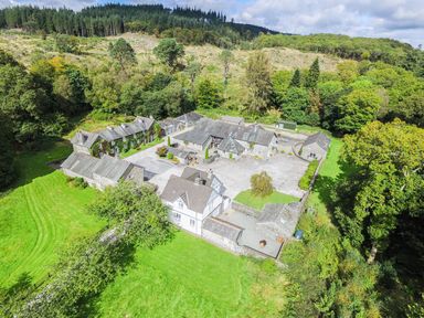 A large estate with multiple stone buildings surrounded by grass and trees at Briar Graythwaite near Hawkshead
