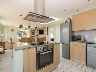 A kitchen with an oven island and stainless steel fridge and microwave in a house