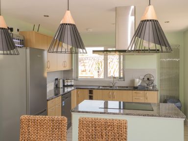 A kitchen with a refrigerator oven sink and island with pendant lights at Bluebell Wood in Brandesburton