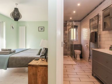 A bedroom with a bed and a bathroom with a shower at Bluebell Wood in Brandesburton