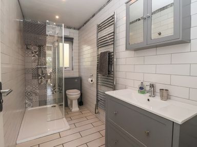 A bathroom featuring a shower, toilet, and sink at Bluebell Wood in Brandesburton