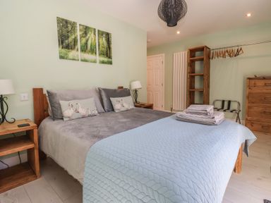 A bedroom with a bed, nightstand, and chest of drawers at Bluebell Wood in Brandesburton