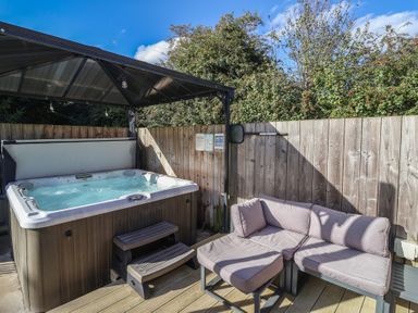 An outdoor area with a hot tub and a sitting area at Bluebell Wood in Brandesburton