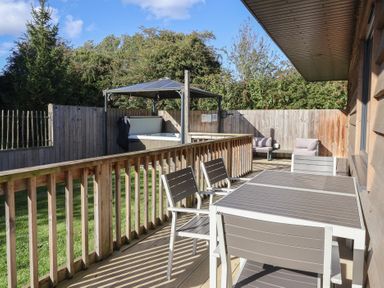An outdoor space with seating and a hot tub at Bluebell Wood in Brandesburton