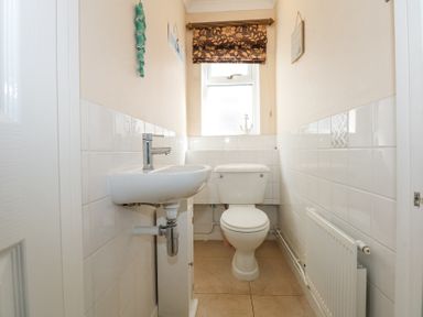 A small bathroom with a toilet sink and radiator at Glanaig in Morfa Bychan