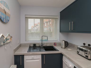 A kitchen corner with a window above a sink next to a kettle, toaster, and appliances at Seadrift The Bay near Filey