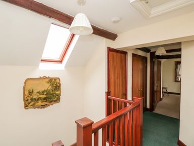 A hallway with wooden doors a skylight and a framed painting at Lawn Farm Cottage in Churcham near Gloucester