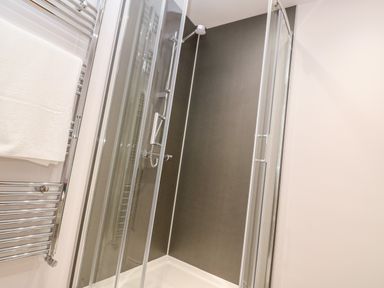 A shower enclosure with glass doors and a towel rack with a white towel at Atlantic View in Germoe