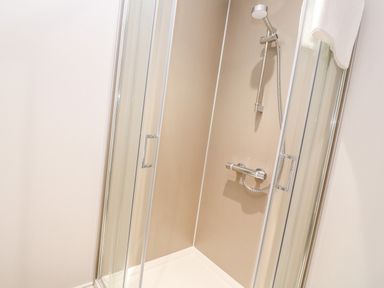 A shower enclosure with sliding glass doors and a handheld showerhead at Atlantic View in Germoe
