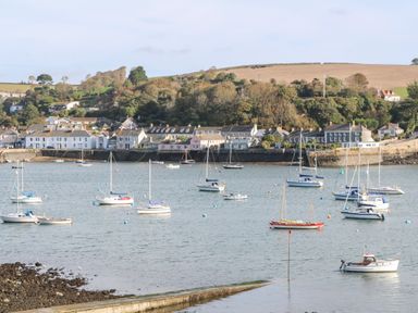 A harbor with multiple sailboats and houses along the shoreline at Atlantic View in Germoe