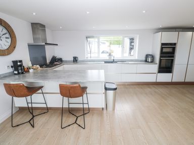 A kitchen with bar stools and counter space at Atlantic View in Germoe