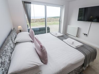 A bedroom with a bed and television at Atlantic View in Germoe