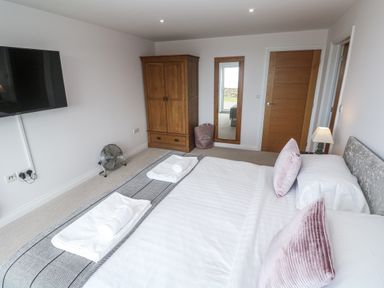 A bedroom with a bed and wardrobe at Atlantic View in Germoe