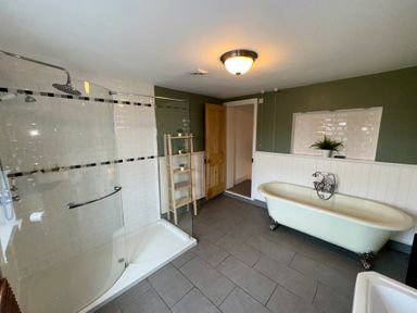 A bathroom with a shower and bathtub at Monfa in Cemaes Bay