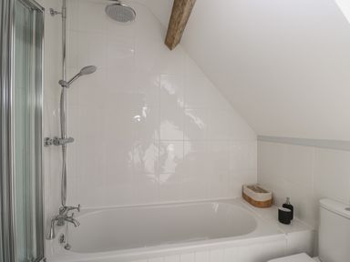 A bathroom with a bathtub showerhead and toilet at Kingfisher 2 The Old Stables in Witney