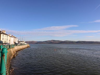 A waterfront with houses on the left side and hills across the water at The Look Out in Aberdovey
