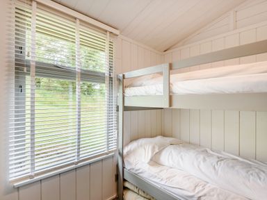 A room with a bunk bed next to a window with blinds at The Look Out in Aberdovey