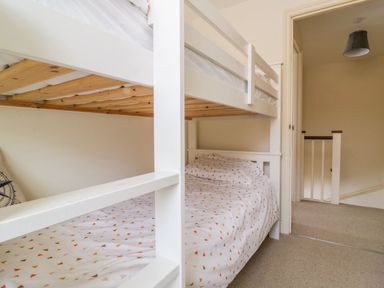 A bunk bed with patterned bedding in a hallway area at 26 Burtons Mill in Stalham