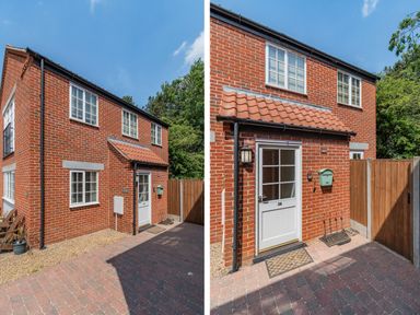 The front exterior of a red brick house with white framed windows a white door a red tiled canopy a green mailbox and a wooden fence at 26 Burtons Mill in Stalham