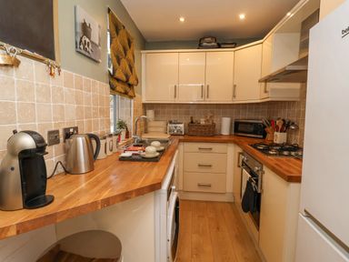 A kitchen with wooden countertops white cabinets and appliances at 202 Salisbury Terrace in York