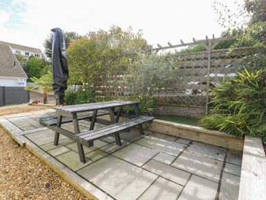 A garden with a picnic table and plants at Daisy Cottage in Benllech