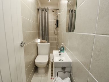 A bathroom with a toilet and a wash basin at Daisy Cottage Benllech