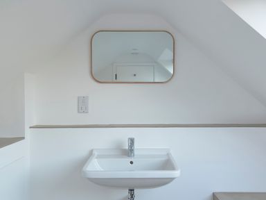 A bathroom sink with a faucet and a mirror on the wall at High Cogges Farm Holiday Cottages - The Cart Shed in High Cogges near Witney