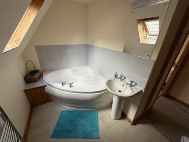 A bathroom with a bathtub and sink at Hembry Meadows near Honicombe Park