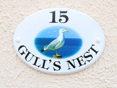 An oval house sign with the number 15 and a seagull image with the text Gulls Nest