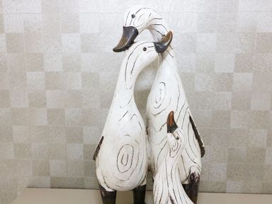 A group of three wooden duck sculptures against a textured wall at 44 Heritage Park in Stepaside near Kilgetty
