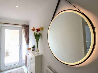 A hallway with a mirror and flower vase at Little Starboard in Kingsbridge