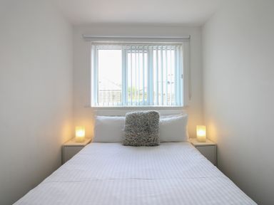 A bedroom with a bed and window at Little Starboard in Kingsbridge