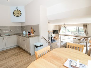 A kitchen and living room with dining table and chairs at Y Stabl in Llanddoged near Llanrwst