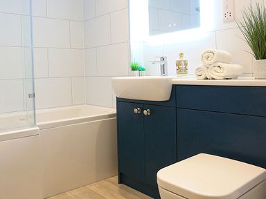 A bathroom with a bathtub and sink at Honeybee Cottage in Penruddock