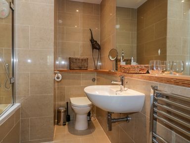 A bathroom with a toilet sink shower and mirror at The Bolt Hole in Downderry