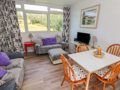 A living room with sofas pillows and a dining table with chairs at Y Twll Bollt (The Bolt Hole) Folkeston Hill Nolton Haven West Wales & Pembrokeshire