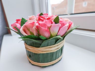 A small basket with pink artificial flowers on a windowsill at Esk Retreat in Whitby