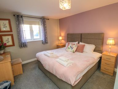 A bedroom with a double bed two bedside tables lamps and a window at Esk Retreat in Whitby