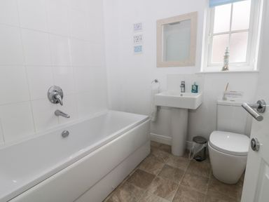 A bathroom with a bathtub a sink and a toilet near a window at Silversands in Filey