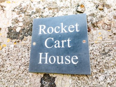 A sign with the words Rocket Cart House mounted on a stone wall at Rocket Cart House in Lizard