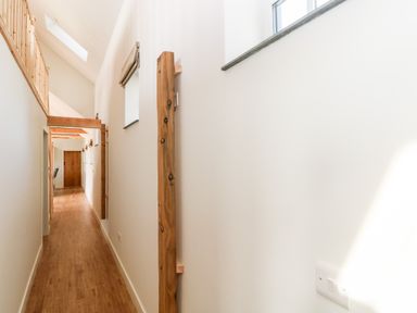 A long narrow hallway with wooden floor and wooden beams on the ceiling at Glowty Brynbedw in Efailwen