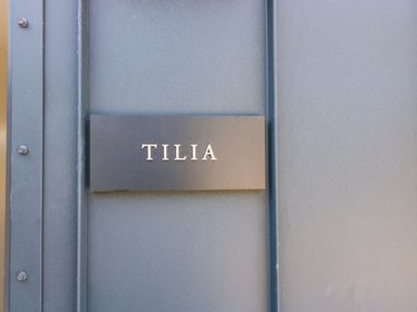 A black nameplate with the word TILIA on a blue door at Tilia Barn in Wincanton