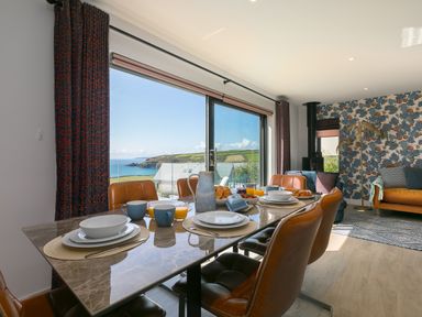 A dining area with a table set for breakfast and a view of the sea at Sea Sands in Praa Sands