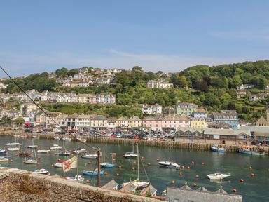 A harbor with boats and buildings along the waterfront at Pixie Cottage in Looe
