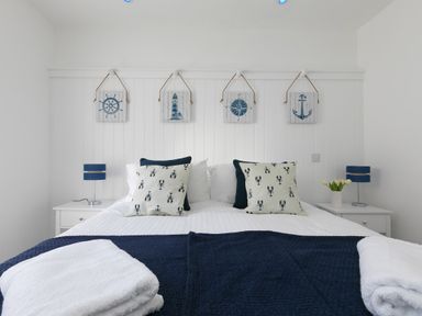 A bedroom with a double bed two bedside tables with lamps and nautical decorations on the wall at 6 Albany Terrace in St Ives