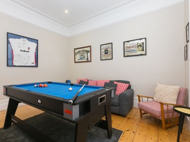 A game room with a pool table couch and armchair at 6 Albany Terrace in St Ives