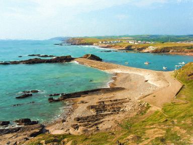 A coastal landscape with rocky shore and boats on the water at Silver Crooks in Trewyn Nr Holsworthy