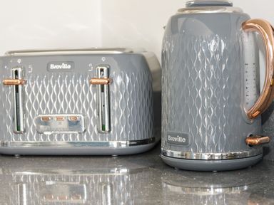 A grey patterned Breville toaster and kettle with copper accents on a kitchen counter at 4 Parc Delfryn Brynteg near Benllech