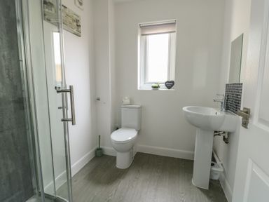 A bathroom with a shower enclosure toilet and sink at 4 Parc Delfryn in Brynteg near Benllech